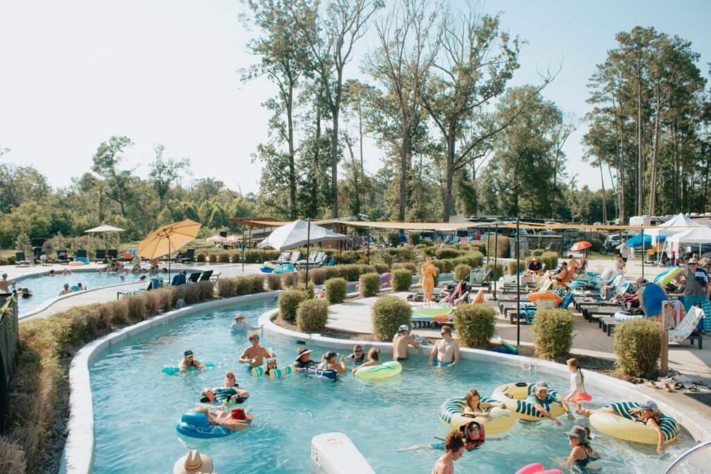 Guests floating on tubes down the lazy river at Fireside RV Resort on a sunny day