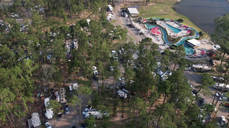 Aerial view of Fireside RV Resort grounds and lake surrounded by pine trees in Ponchatoula, Louisiana