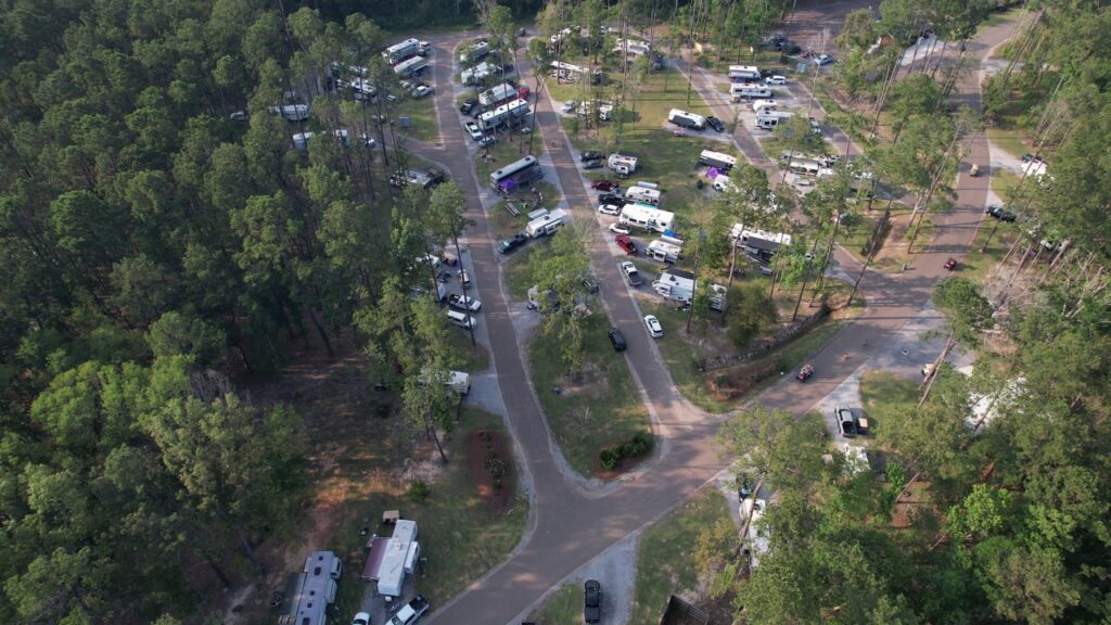 Aerial view of full-hookup RV sites among pines at a Louisiana Northshore RV resort