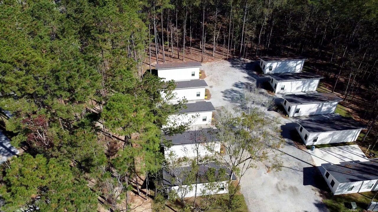 Aerial view of furnished cabins tucked in the pines at Fireside RV Resort
