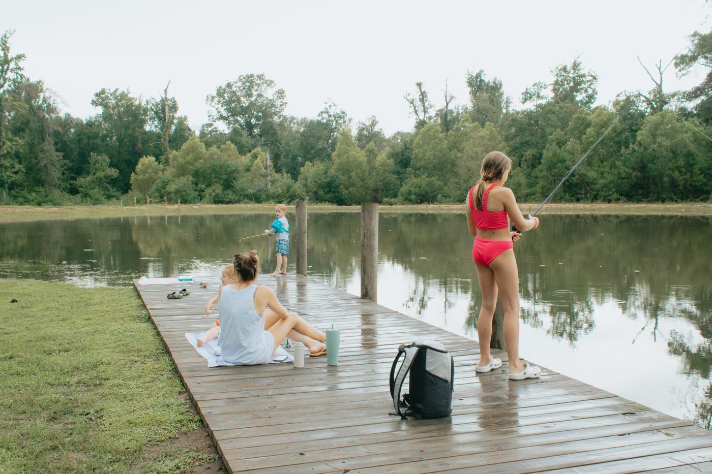 A family fishing off the lakeside dock at Fireside RV Resort at dusk