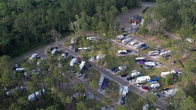 Aerial view of RV sites among pine trees at Fireside RV Resort, a campground near New Orleans