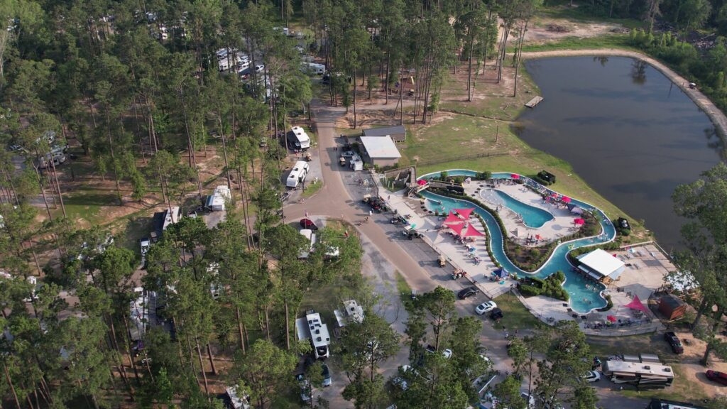 Aerial view of Fireside RV Resort with lazy river, pools, and shaded RV sites near Mandeville