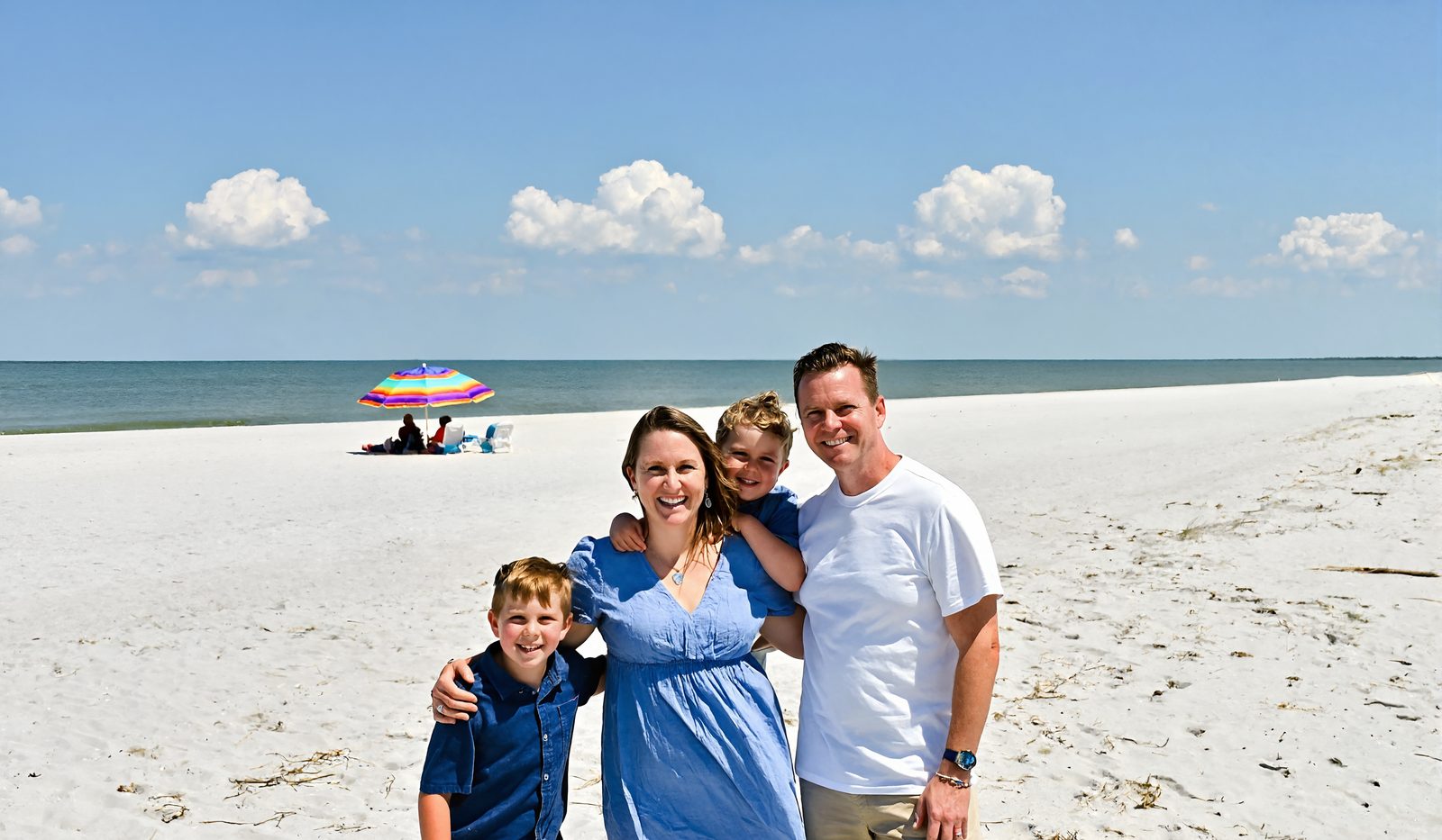 A family enjoying the white sand and calm water of the Mississippi Gulf Coast beach