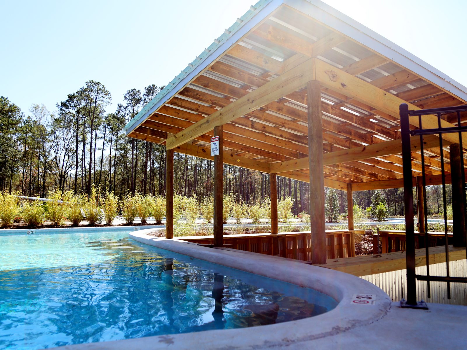 Fireside RV Resort swimming pool with a covered wooden pavilion among tall pines