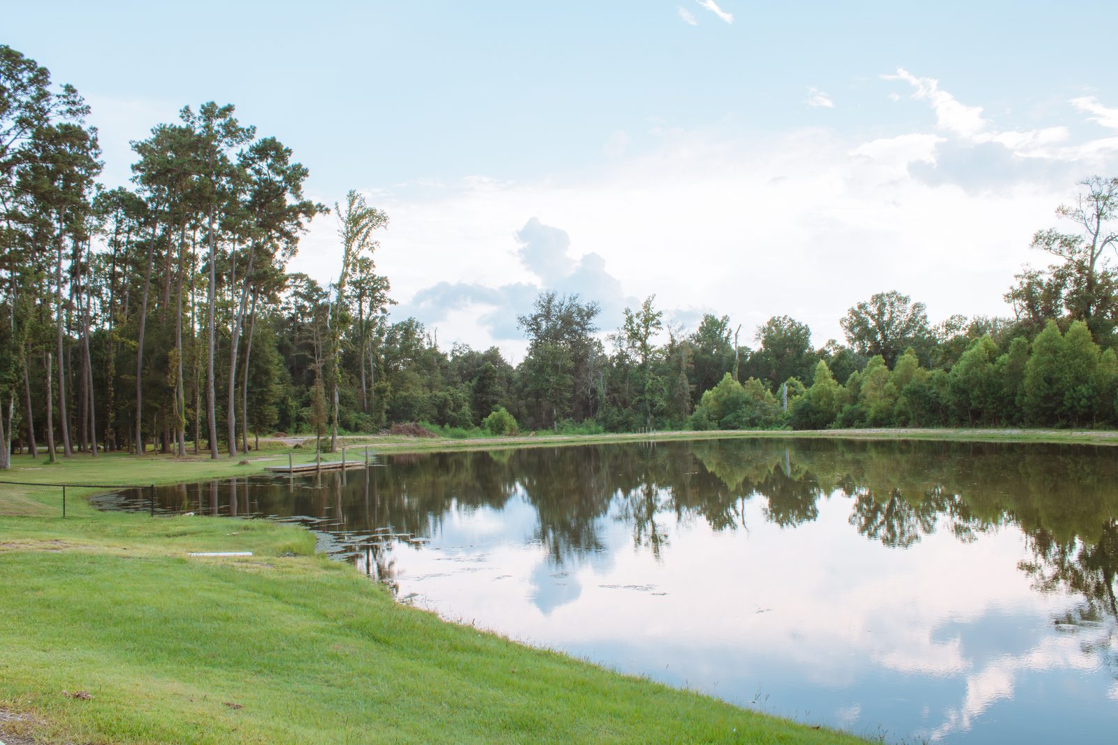 Still pond reflecting pines and sky at Fireside RV Resort