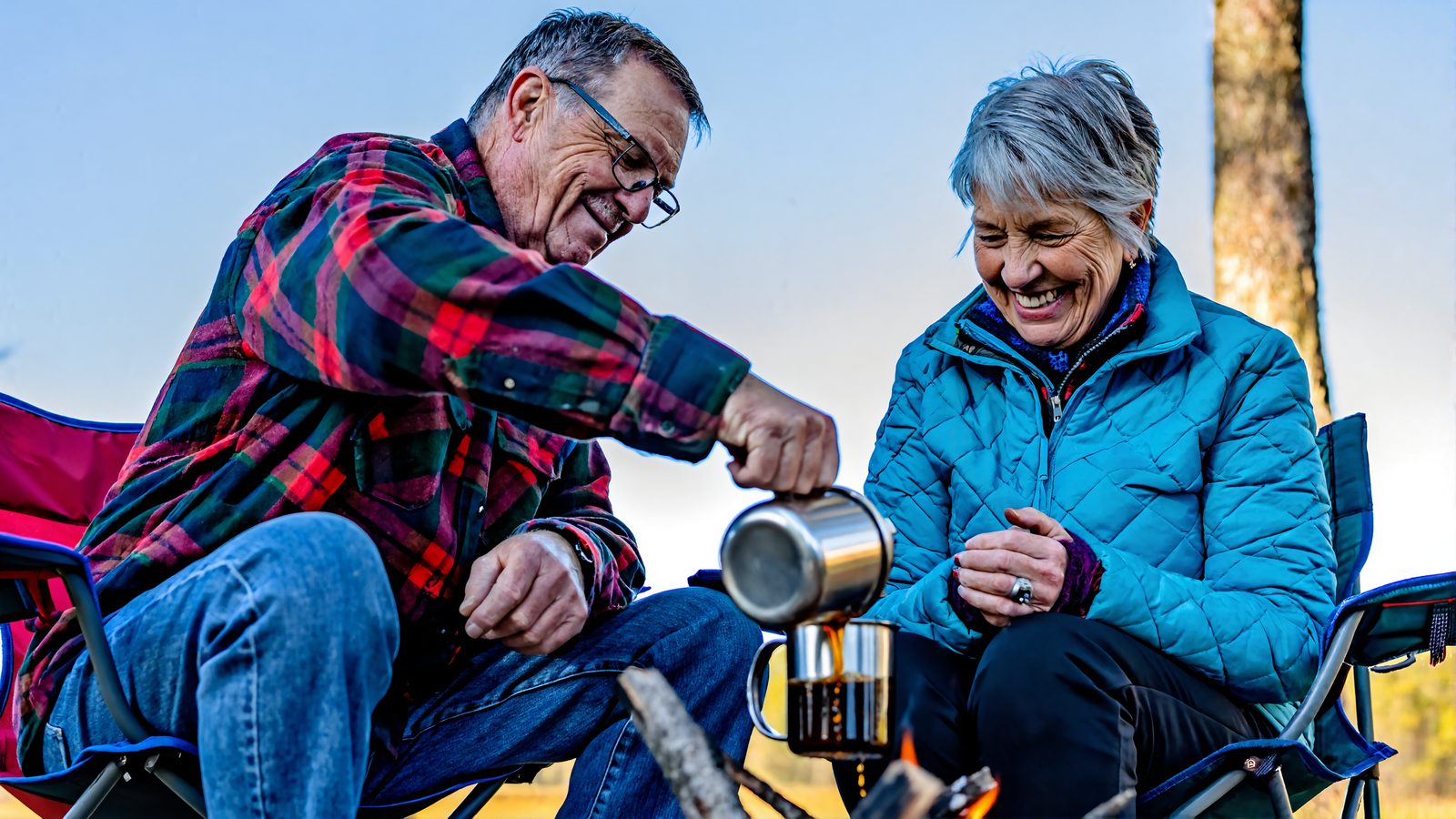 A retired couple pouring morning coffee by a campfire on a mild winter day on the Louisiana Northshore