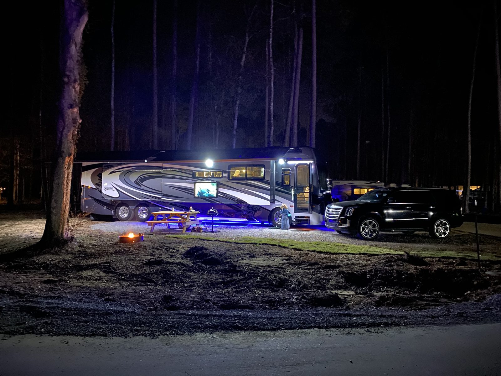 An RV at a wooded full-hookup site with a campfire at Fireside RV Resort in Ponchatoula, Louisiana