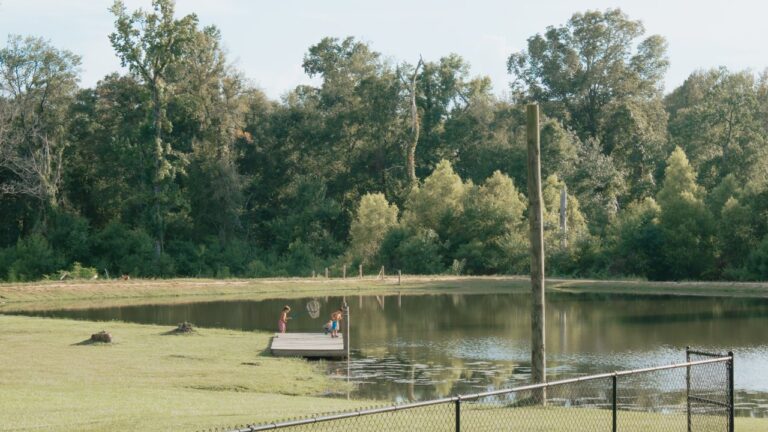 Kids fishing off a dock on the quiet lake at Fireside RV Resort near Honey Island Swamp tours on the Northshore