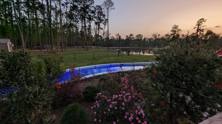 Glowing blue resort pool and calm lake at twilight in Ponchatoula, Louisiana