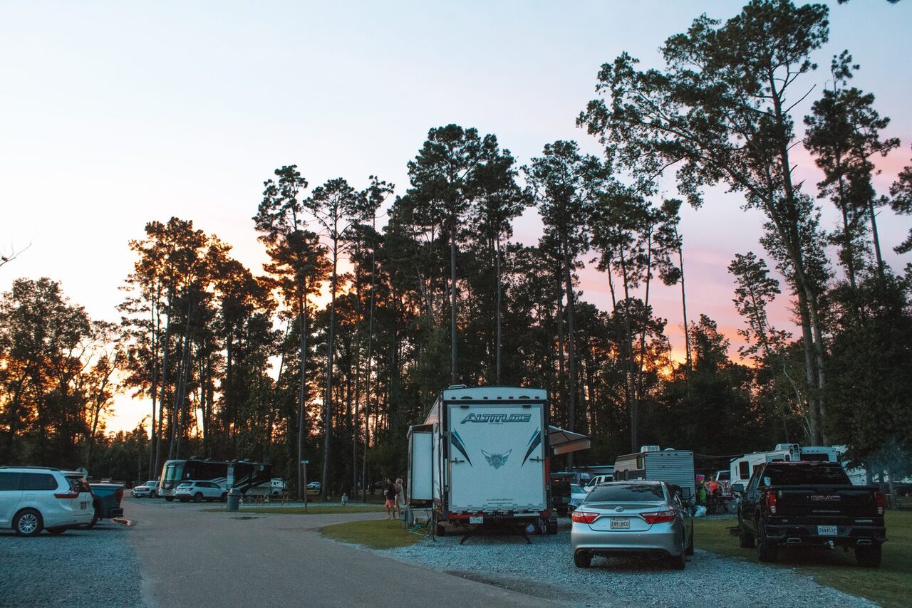 Sunset behind tall pines over parked RVs at a long term RV park near Baton Rouge, Louisiana