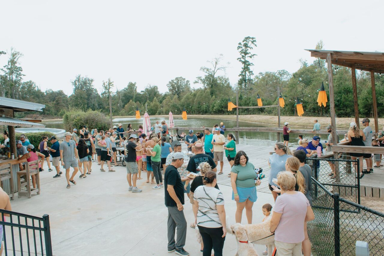 Guests gathered on the lakeside patio near the pavilion at a Louisiana RV resort on a fall afternoon