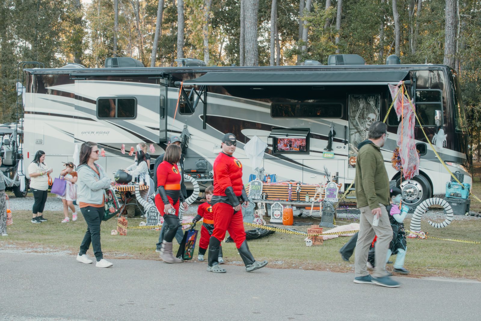 Costumed trick-or-treaters walking past a big motorhome parked at its site at Fireside RV Resort in Ponchatoula, Louisiana