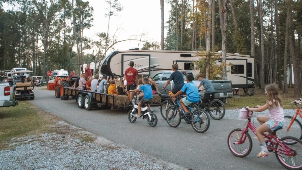 Kids ride bikes beside a tractor-pulled hayride past RV sites at Fireside RV Resort in Ponchatoula, about an hour from the Audubon Zoo and Aquarium in New Orleans