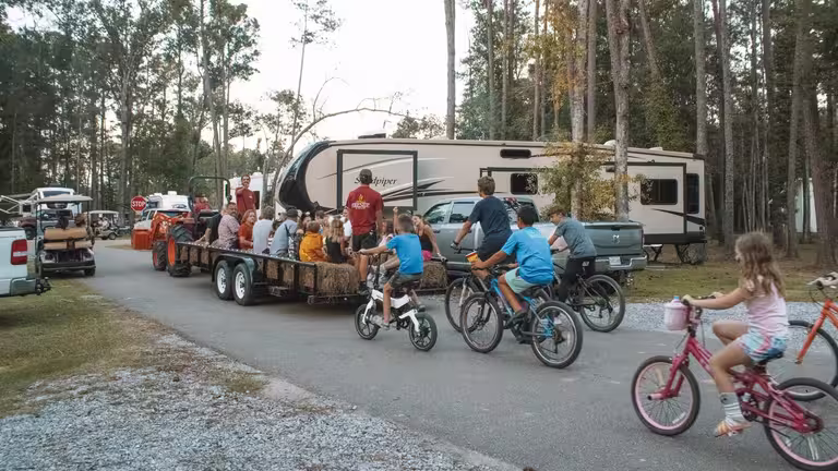 Kids ride bikes beside a tractor-pulled hayride past RV sites at Fireside RV Resort in Ponchatoula, about an hour from the Audubon Zoo and Aquarium in New Orleans