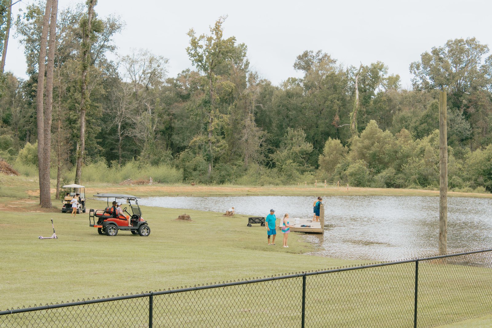 Golf carts and guests beside the lake at Fireside RV Resort in Ponchatoula, Louisiana
