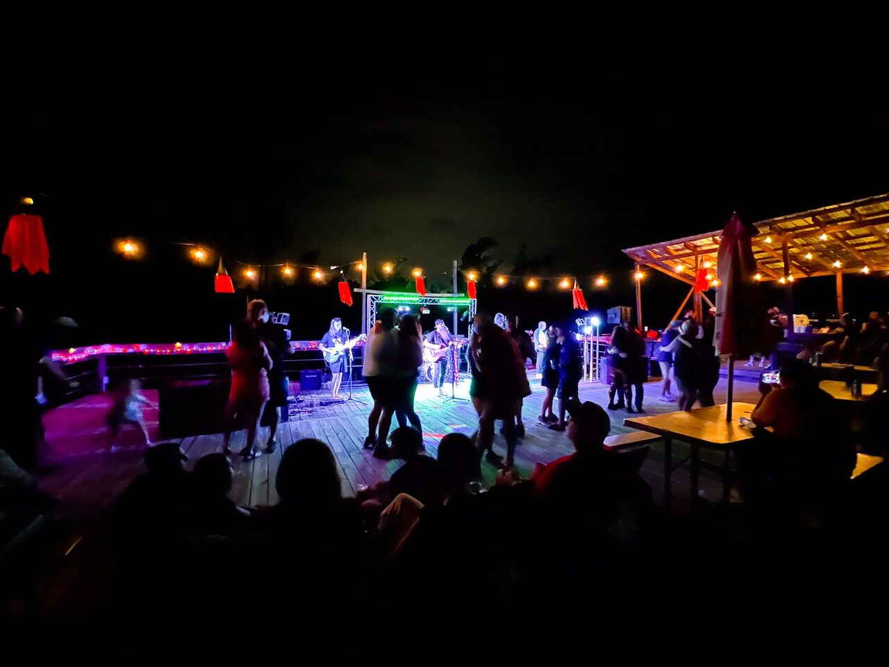 Guests dancing to a live band under string lights on the outdoor deck at night at Fireside RV Resort in Ponchatoula, Louisiana