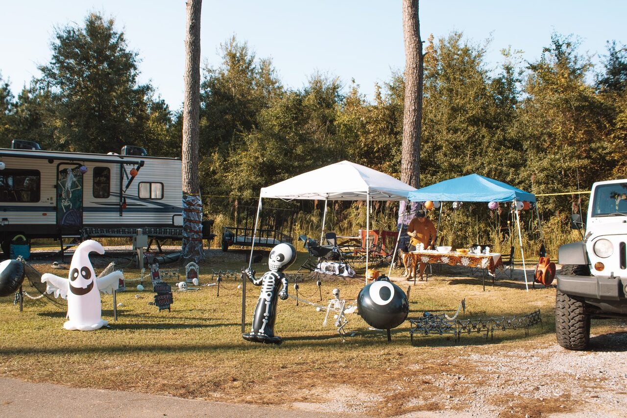 Travel trailer on an RV site decorated with an inflatable ghost, skeletons and party canopies for Halloween at Fireside RV Resort near Ponchatoula, Louisiana