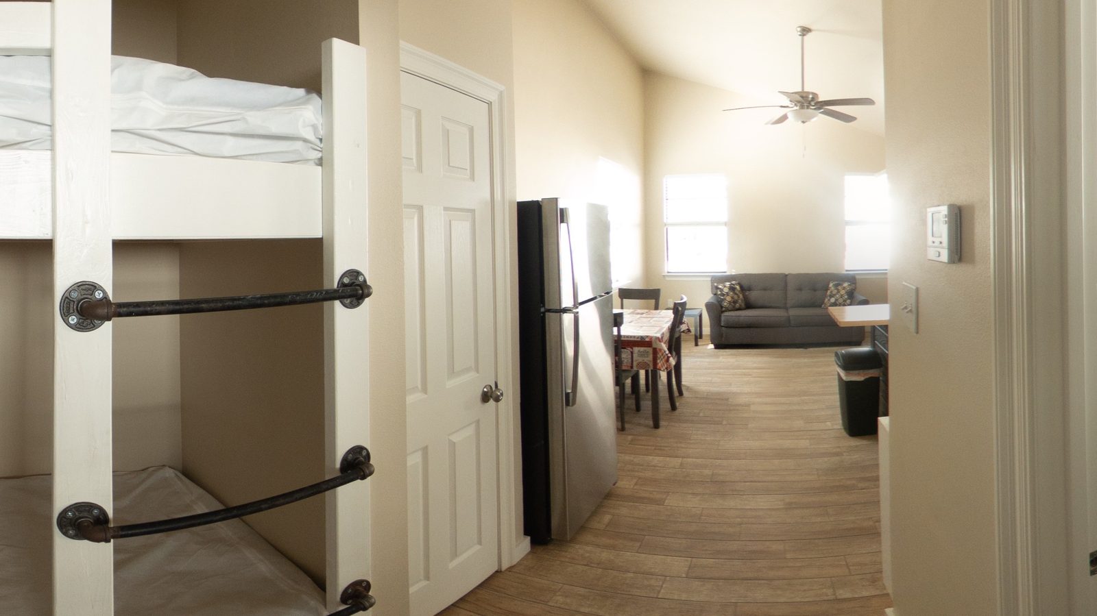 Twin bunk beds, a refrigerator and the living area inside a glamping cabin at Fireside RV Resort near New Orleans