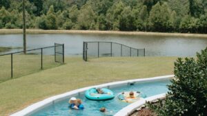 Guests float in tubes on the lazy river beside the pond at Fireside RV Resort, an RV park with pool access in Ponchatoula, Louisiana